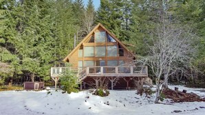 A cabin with a wooden exterior, large windows, and a balcony. - Trails End | Hot Tub, Starlink, Woodstove (Packwood)