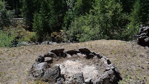 Una estructura de piedra circular rodeada de un área boscosa.
