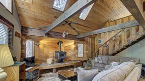 A cozy cabin interior with a wooden interior, a fireplace, a sofa, and a staircase. - Lake Creek Retreat| Mt Rainier, WiFi, Woodstove (Packwood)