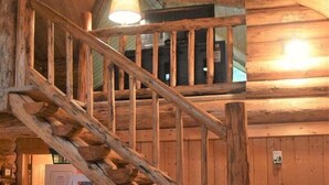 A wooden staircase with a handrail leading to a second-floor area.
