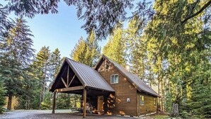 Eine Hütte mit überdachter Veranda, umgeben von Bäumen.