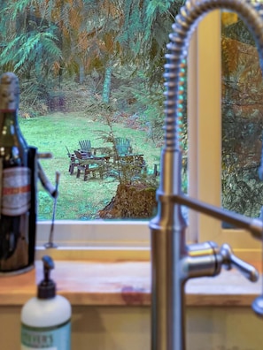 Un baño con vistas a una zona boscosa a través de una ventana.