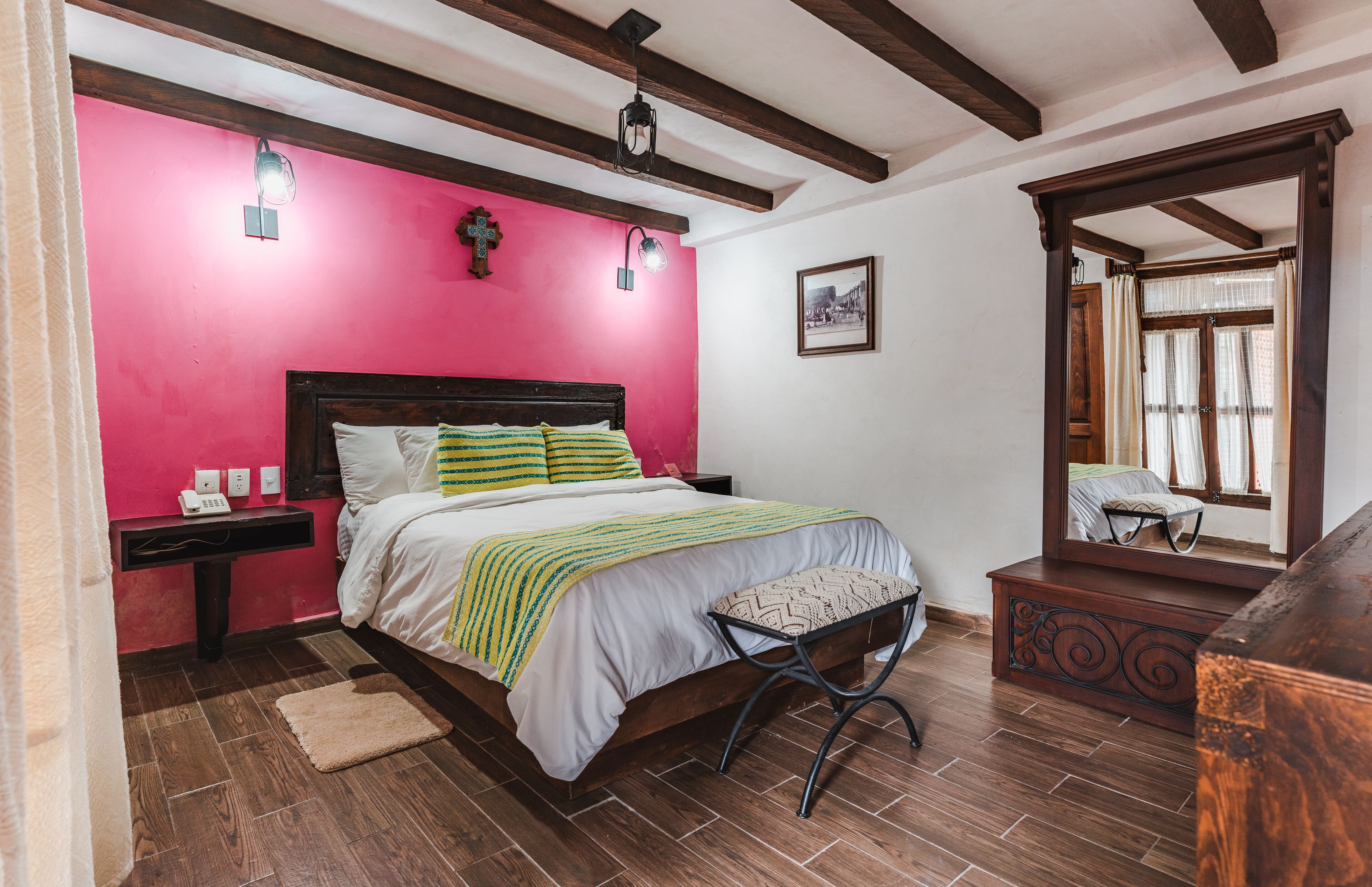 Une chambre à coucher avec un lit, une table de chevet, une commode et un miroir.