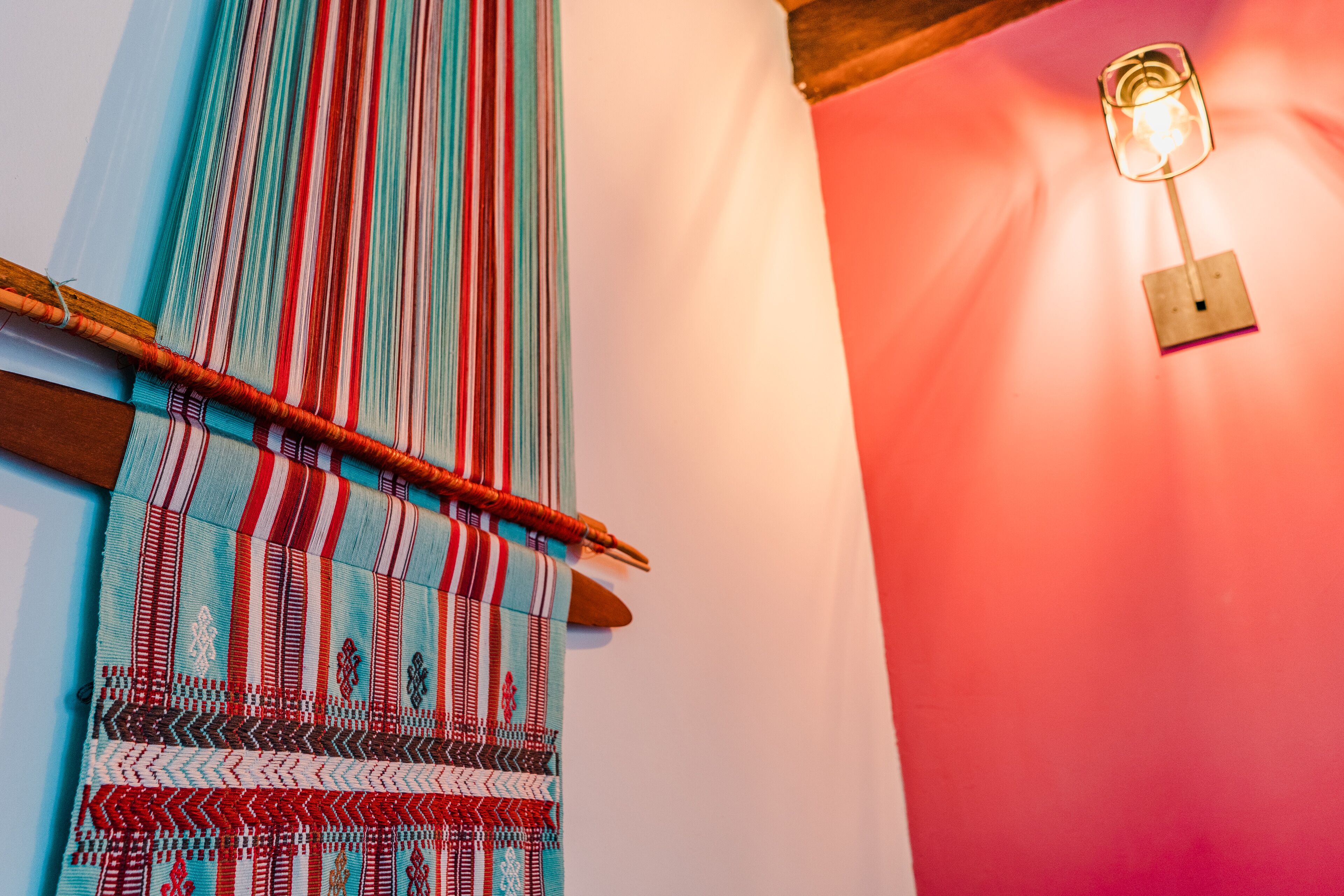 A woven textile with a wooden frame on a wall.