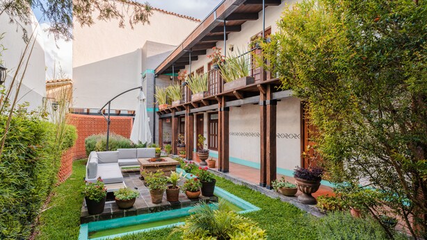 A courtyard with a seating area, potted plants, and a small pool. - Yox Hotel Boutique (San Cristóbal de las Casas)