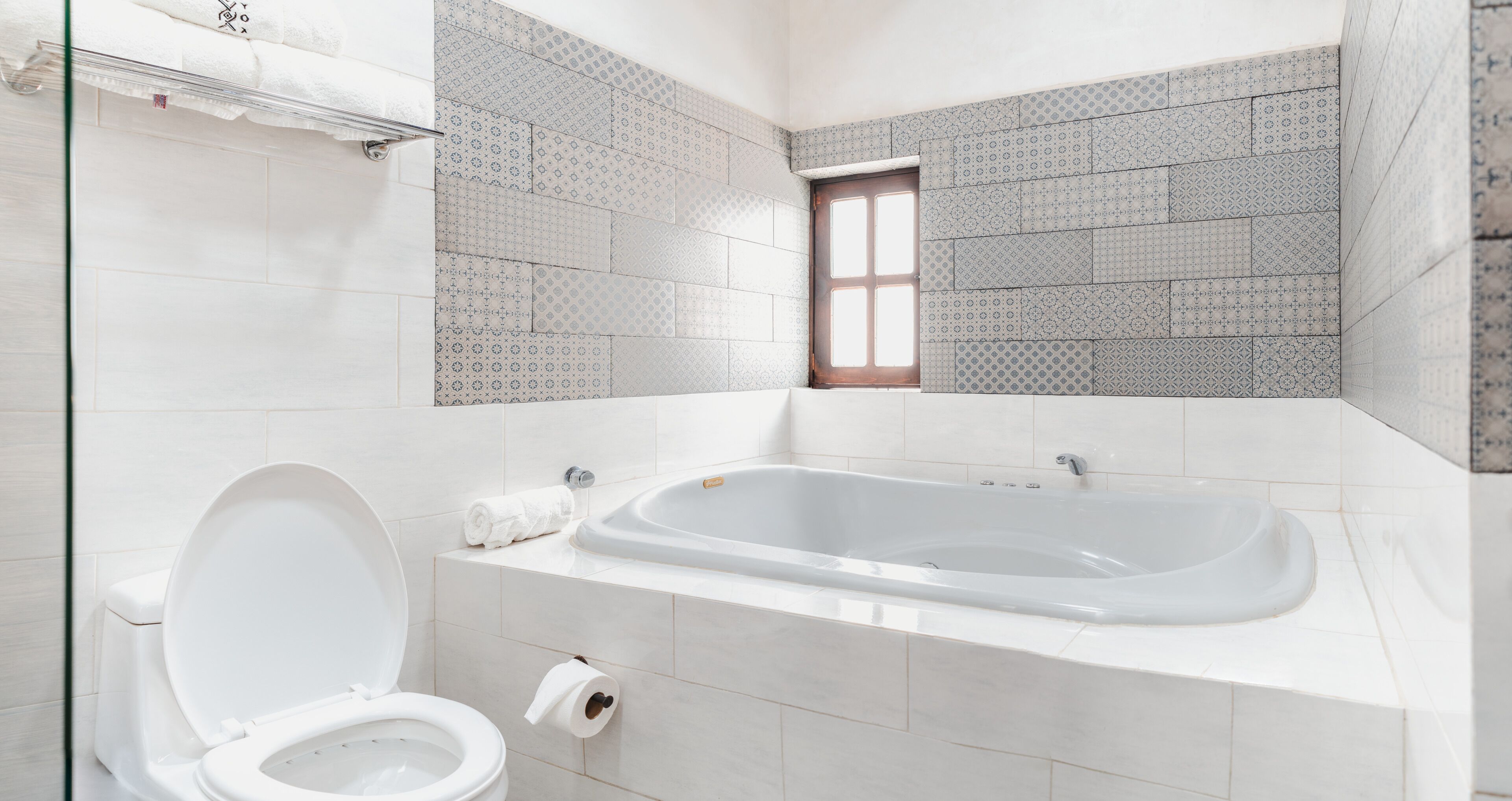 Un bagno moderno con vasca, servizi igienici e piastrelle decorate.