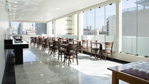 Un comedor amplio con techos altos, ventanas grandes y vistas a la ciudad.