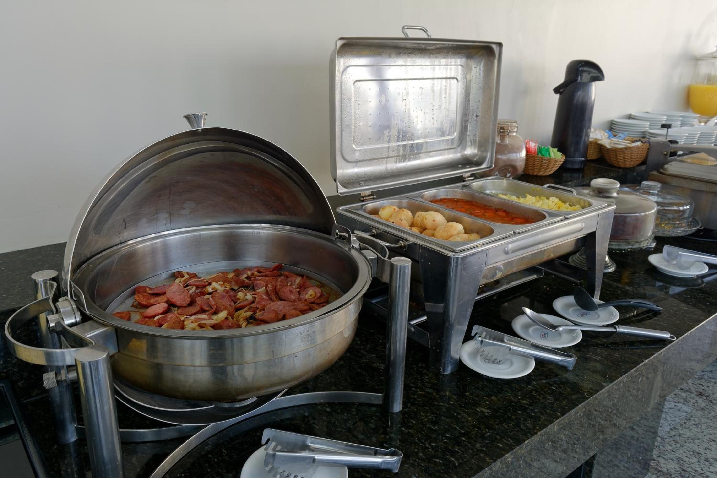 A buffet setup with various food items and utensils.