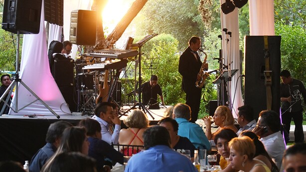A stage with musicians performing, surrounded by seated guests. - Cabañas Quinta Patricia (Tequisquiapan)