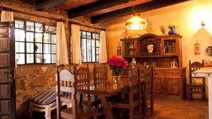 A rustic dining area with a wooden table, chairs, and a chandelier. - Cabañas Quinta Patricia (Tequisquiapan)