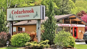 Un letrero de Cedarbrook at Killington y un edificio con la indicación Cedarbrook Office.
