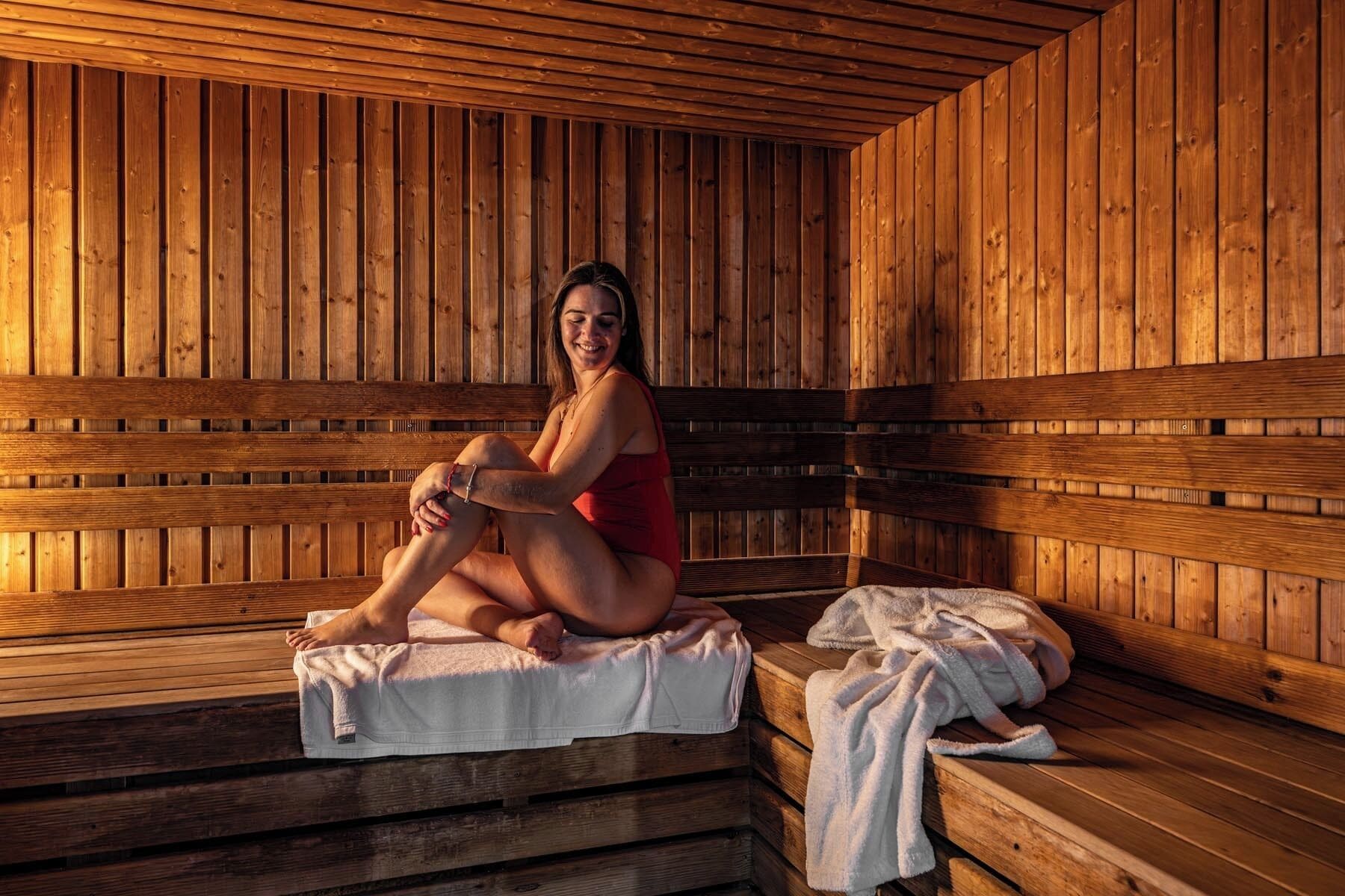 A wooden sauna with benches and benches with towels.