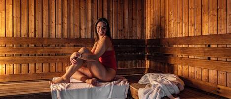 A wooden sauna with benches and benches with towels.