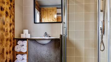 Une salle de bain avec une douche à parois de verre, un lavabo et des toilettes.