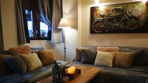 A cozy living room with a sofa, a wooden coffee table, and a lamp. - Dandy Villas Bansko | Winter Nest 1 | Prv Apartm (Bansko)