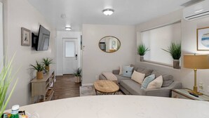 A compact living space with a sofa, coffee table, and a dining table. - Cozy & Chic 2br Retreat In Mission Beach (San Diego)