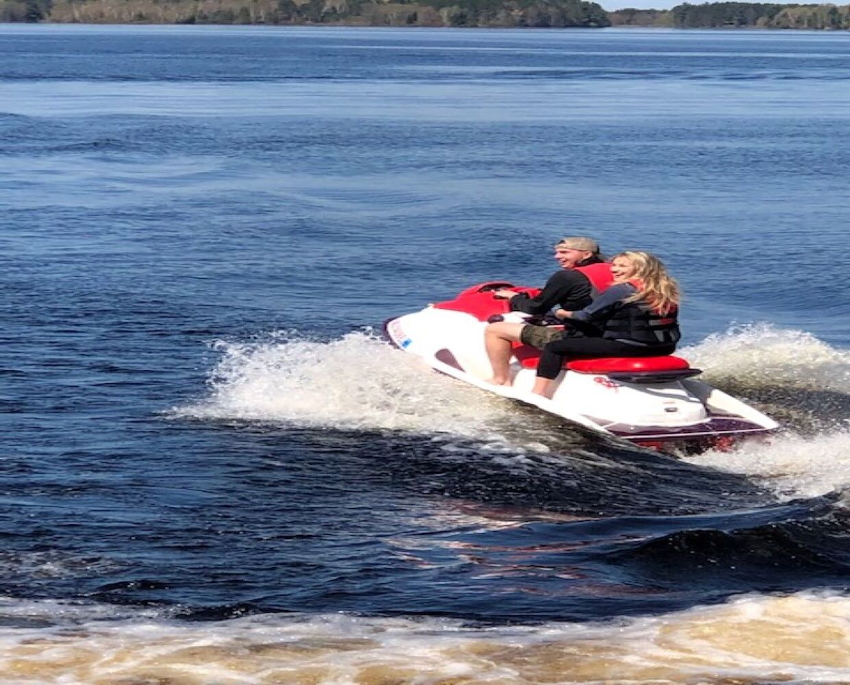 Two people on a jet ski in a body of water.