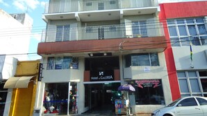 Un hotel con restaurante en la planta baja y balcón en el segundo piso.
