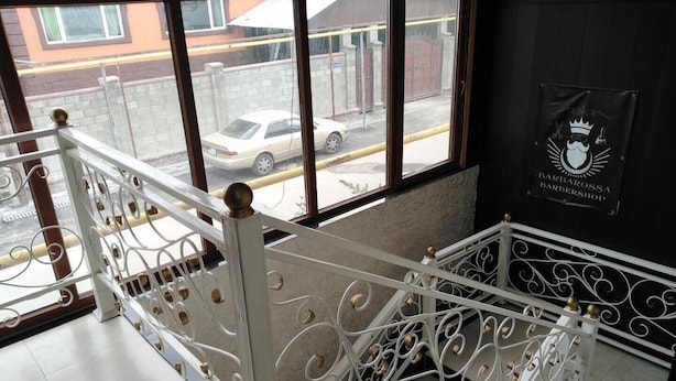 Un escalier orné de rampes blanches et offrant une vue sur une voiture garée à l’extérieur.