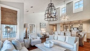 A spacious living room with a large sofa, a coffee table, and a dining area. - Treetop Escape Loft - Close to Shopping & Dining, Free Bikes/Fitness/Tennis (Rosemary Beach)
