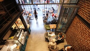 Cafetería interior con mesas y sillas dispuestas para comer.