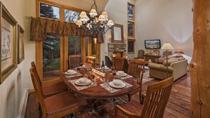 A dining area with a round table set for six, surrounded by wooden chairs. - Luxe Arrowhead Home + Walk to Lift | Chalet Punto (Edwards)