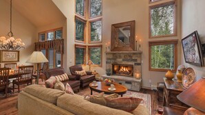 A spacious living room with a fireplace, large windows, and a cozy seating area. - Luxe Arrowhead Home + Walk to Lift | Chalet Punto (Edwards)