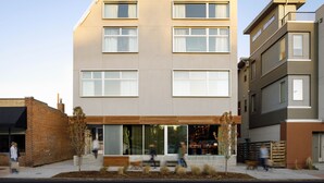 Un immeuble moderne à plusieurs étages, doté de grandes fenêtres et d’un toit plat.