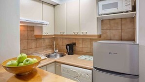 A compact kitchen with a microwave, a coffee maker, and a dishwasher.