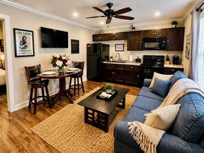 A modern kitchen with dark wood cabinets, a black refrigerator, and a microwave.