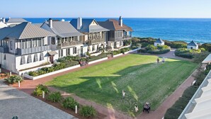 Un hôtel situé sur la côte, doté d’une grande pelouse, offrant une vue sur la mer et disposant d’un chemin menant à l’entrée.