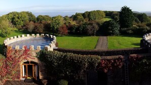 A castle with a circular courtyard, stone walls, and a grassy lawn. - Majestic 17th-century castle in stunning Somerset countryside. Pet friendly. (Clevedon)