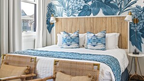 A bedroom with a large bed, two wicker chairs, a wooden headboard, and a floral wall mural. - 201 Rosemary Beach Inn - Includes Beach Chairs & Complimentary Breakfast + Access to 4 Pools (Rosemary Beach)