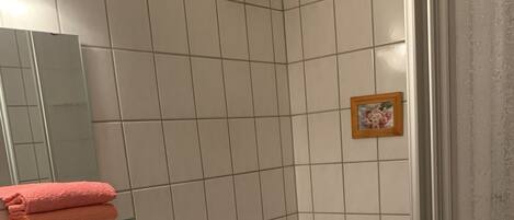 Un baño con lavamanos, inodoro y zona de ducha.