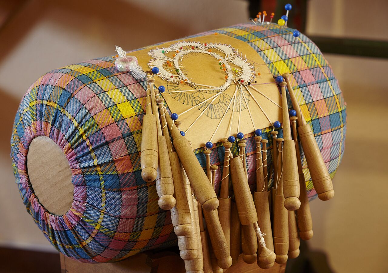 A colorful quilted fabric with a circular cutout and wooden sticks attached to it.