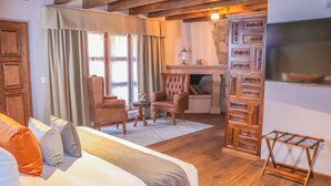 A cozy room with a bed, two armchairs, a small table, and a fireplace. - Gamma Morelia Vista Bella (Morelia)