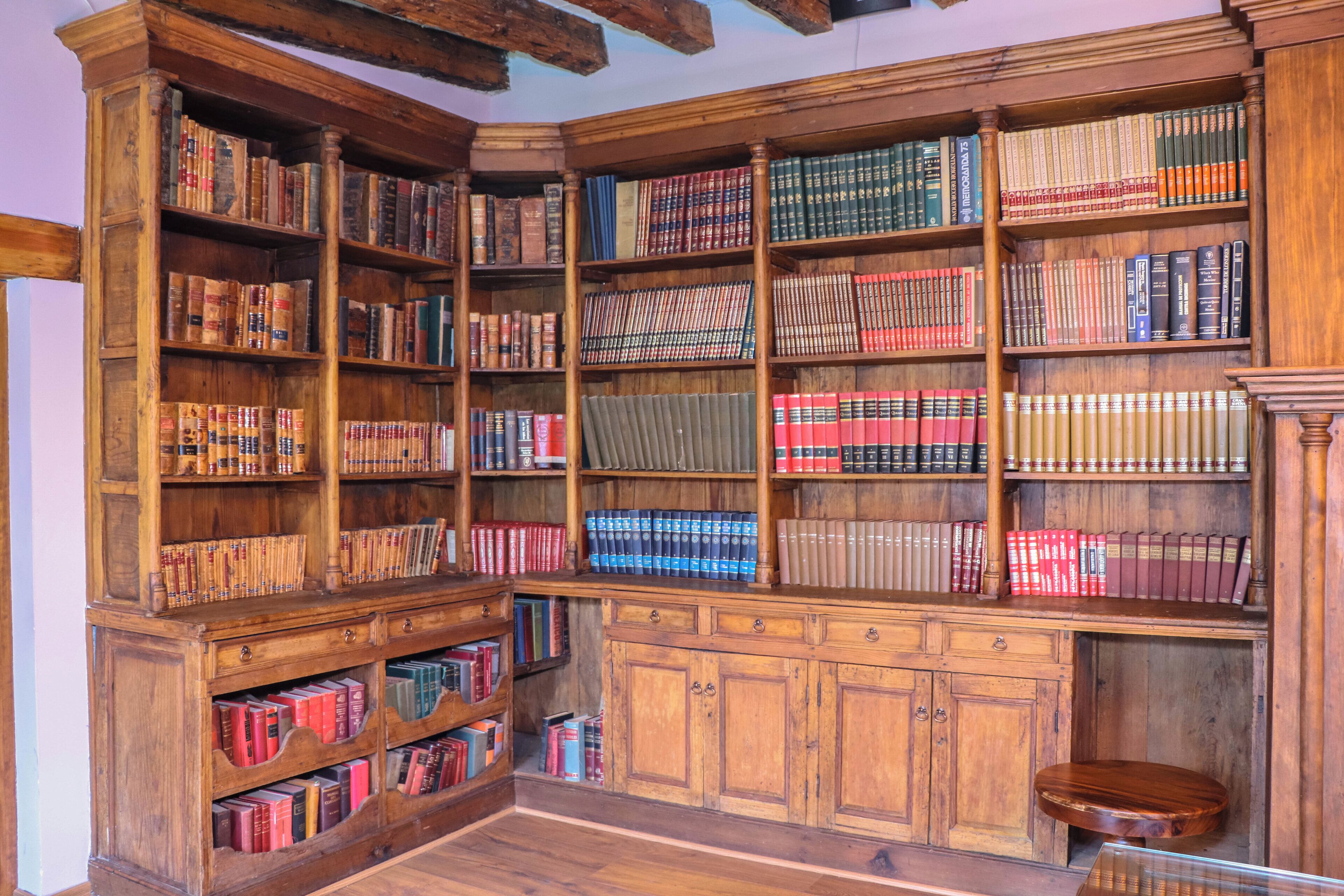 A library with wooden bookshelves filled with books.
