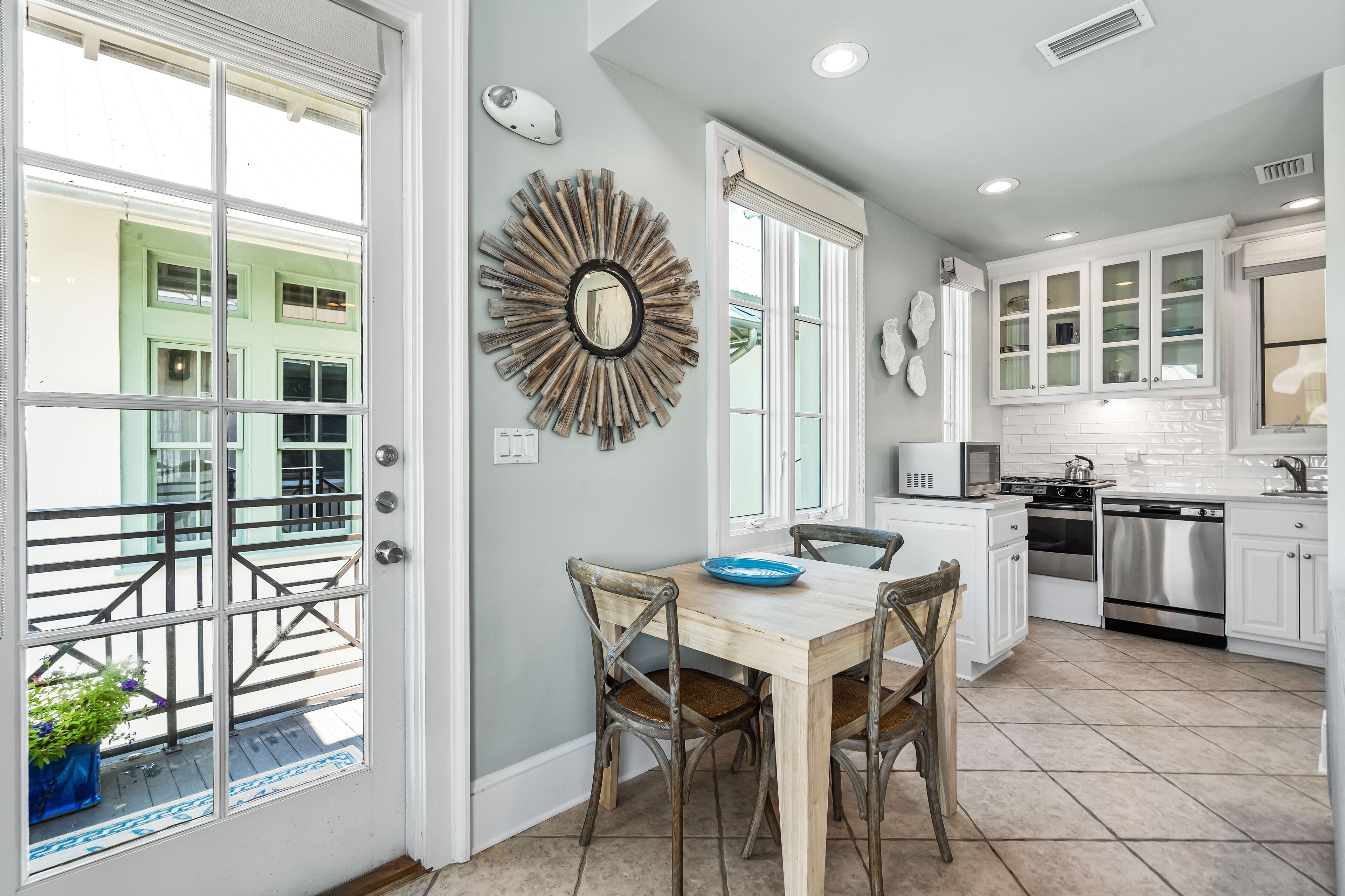 A kitchen with white cabinets, a wooden dining table, and a blue bowl.
