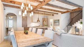 A spacious kitchen with a wooden dining table, a built-in island, and pendant lighting.