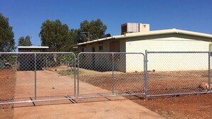 A fenced area with a building that has a flat roof and a light-colored exterior wall. - Blue Moon - Family friendly, comfy home. (Exmouth)