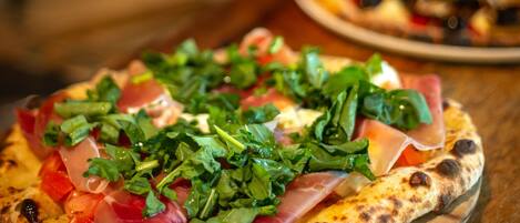 Una pizza con ingredientes sobre una tabla de madera.