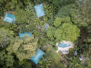 An aerial view of a resort with multiple buildings, a swimming pool, and lush vegetation. - El Nido Jungle Lodge (Cahuita)