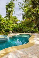 Una piscina al aire libre, sillones reclinables de piscina