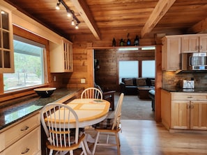 Interior de una cabaña de madera con cocina, comedor y sala de estar.