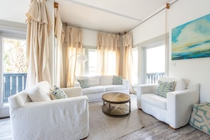 Living Area with Sofas, Coffee Table, Floor Lamp, and Windows.