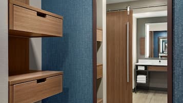 Une salle de bain moderne avec un meuble-lavabo en bois, un mur bleu à texture et un espace douche bien délimité.