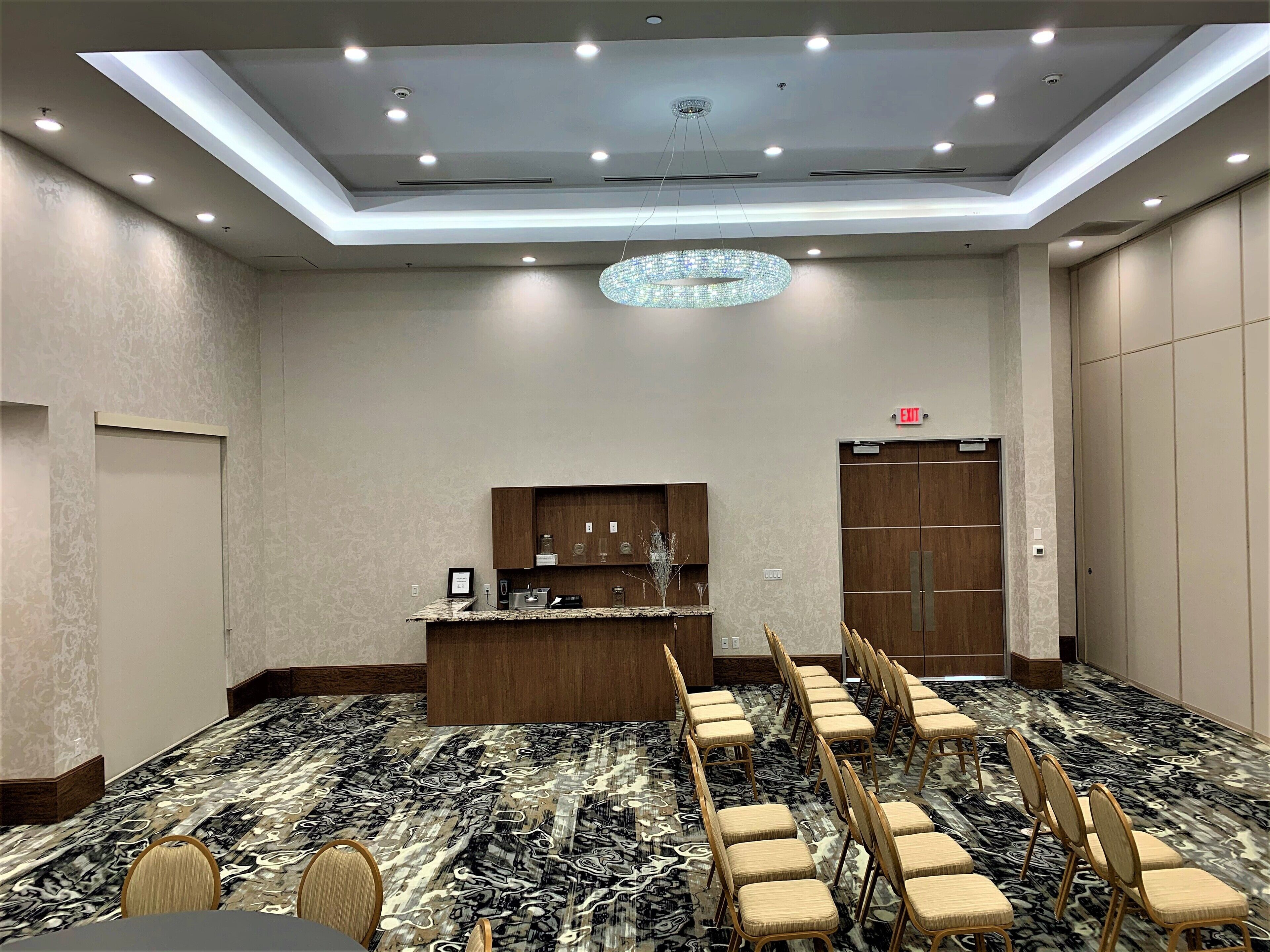 A conference room with a long table, chairs, a reception desk, and a chandelier.