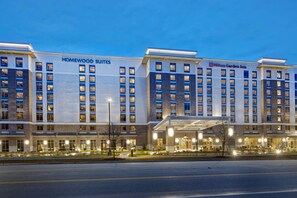 Un hôtel à l’architecture moderne, dont la façade est ornée de deux enseignes bien visibles, l’une pour Homewood Suites et l’autre pour Hilton Garden Inn.