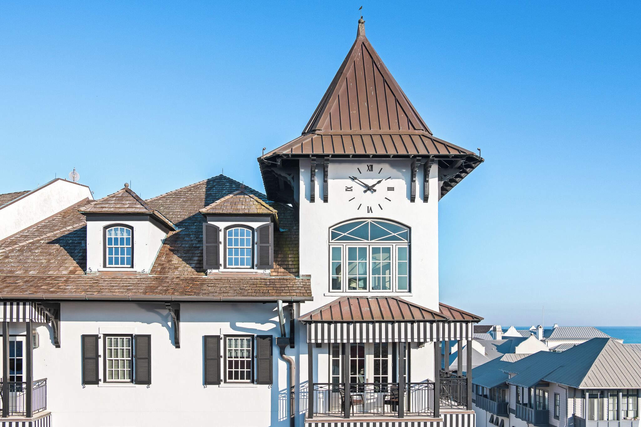 Ein Gebäude mit einem Glockenturm, zahlreichen Fenstern und einem Balkon mit Geländern.