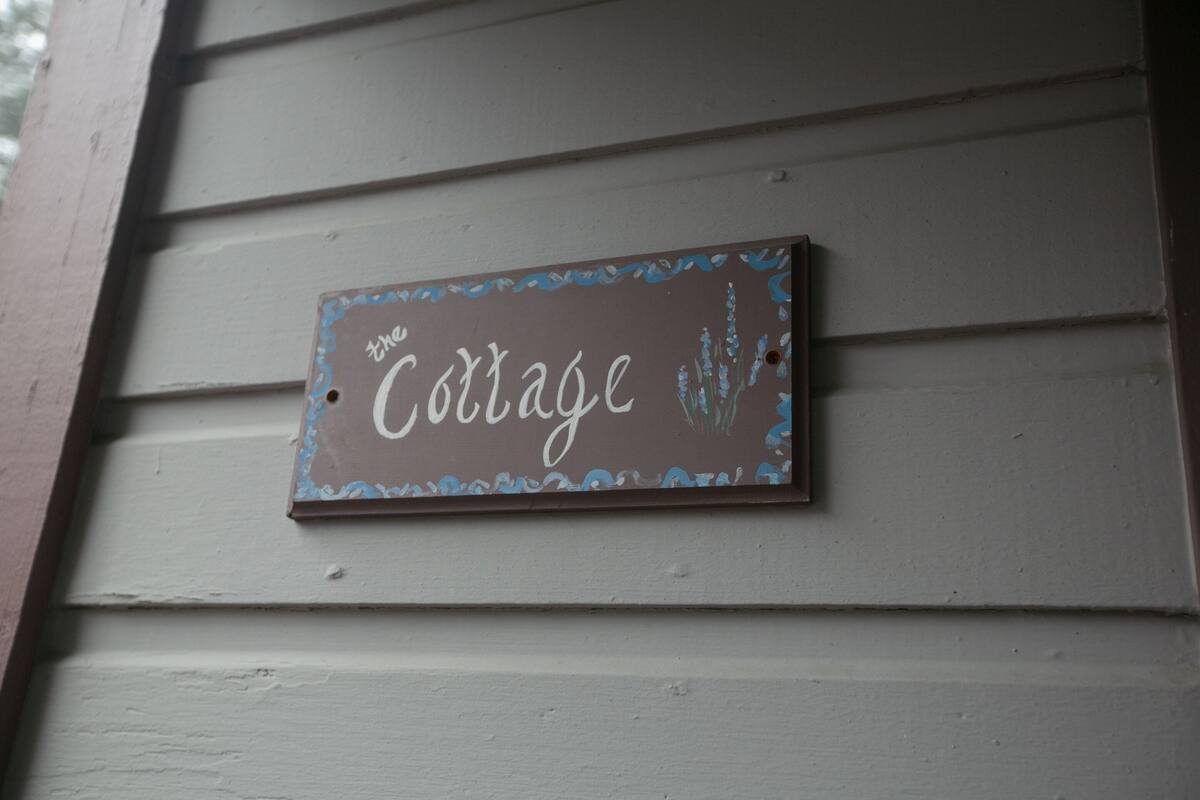 A sign on a building that reads "The Cottage."